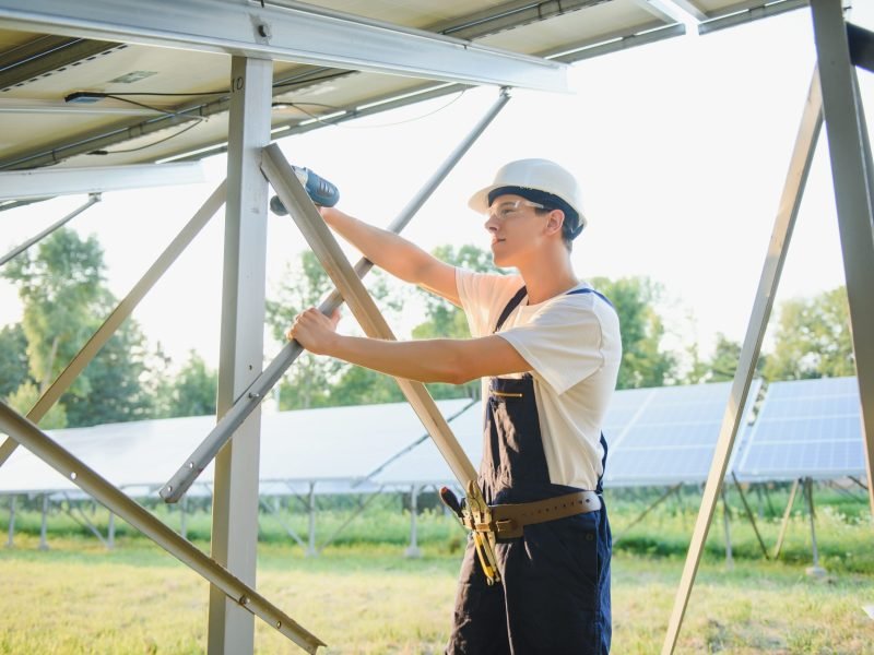 Worker installing solar panels outdoors